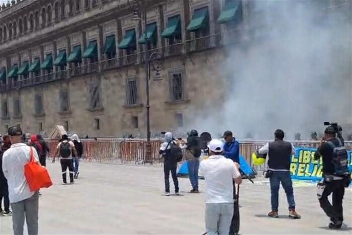 Normalistas de Ayotzinapa tiran cohetes contra fachada de Palacio Nacional